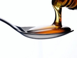 Pouring honey on a spoon.
