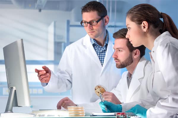 trainees-wearing-protective-lab-wear-with-instructor