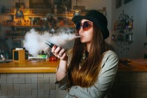 Young girl vaping e- cigarette